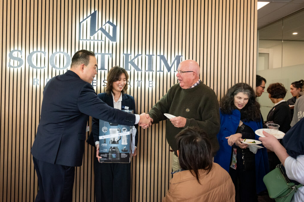 Scott Kim Real Estate team greeting a guest at the office event